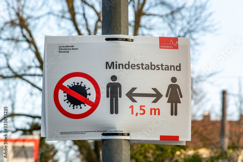 NUERNBERG, GERMANY - March 27, 2020: Sign in German about keeping a minimum distance due to the Corona Virus photo