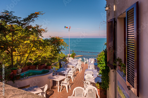 A sunny restaurant outdoor terrace overlooking the Adriatic Sea on the Italian Riviera, Numana, Marche, Italy