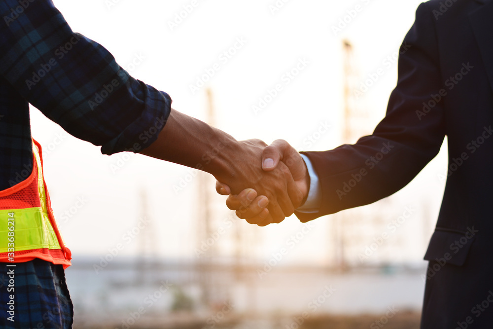 Business people and engineers shake hands