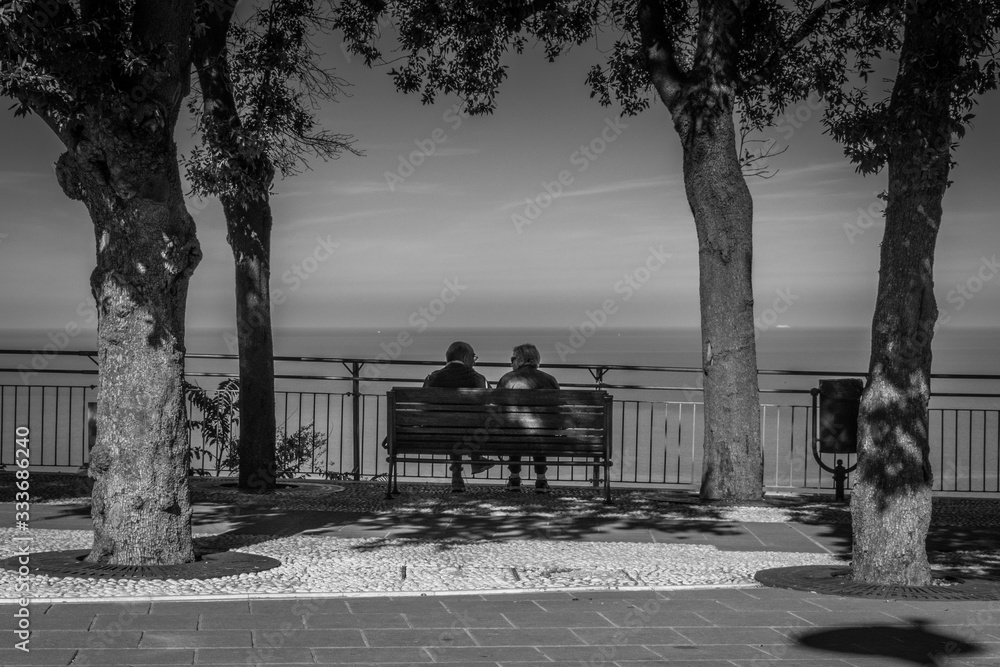 Old couple chat while overlooking the panoramic view of the Adriatic Sea on the Italian Riviera, Sirolo, Italy