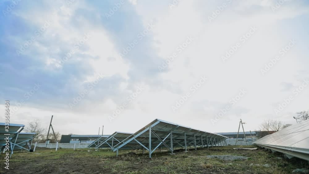 Solar energy farm on the field. Solar panels attached on metal basis on the ground. Renewable source of energy. View from below. Solar energy farm on the field. Solar panels attached on metal basis on the ground. Renewable source of energy. View from below.