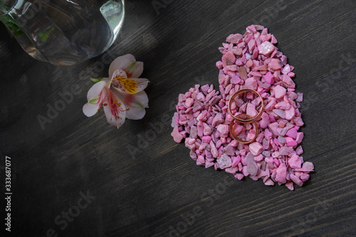 Wedding ring and icing heart shape cookie for wedding image. Valentine's day background-pink heart and wedding rings on dark wooden background