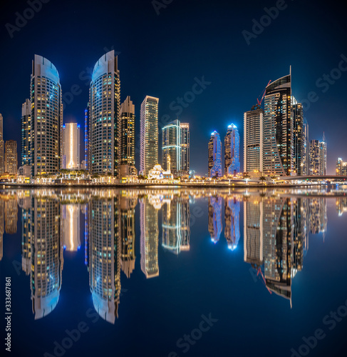 Canvas Print Panoramic view with modern skyscrapers and water pier of Dubai Marina at night,
