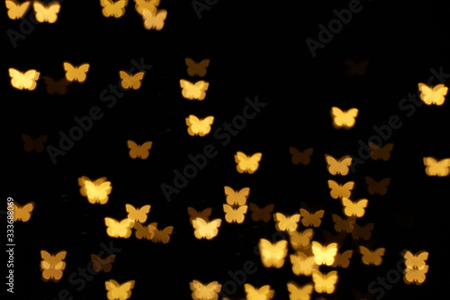 Photography Blurred view of butterfly shaped lights on black background