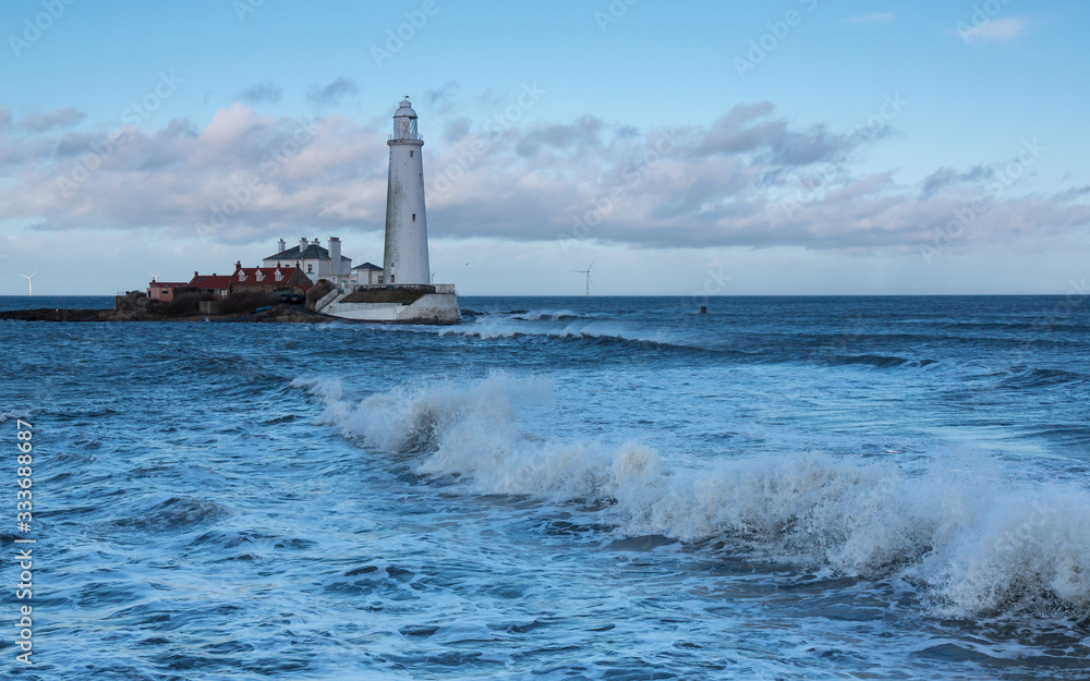 Rough sea and waves over the causeway to St Marys Island and Lighthouse, Whitley Bay. Tyneside, England, UK.
