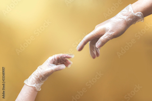 creation of Adam like hands wearing latex gloves on beige background photo