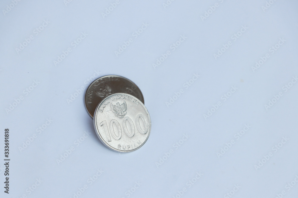 Two coins of one thousand Rupiah Indonesia money on the white background. Concept of finance. Two coins of one thousand Rupiah Indonesia money on the white background. Concept of finance.