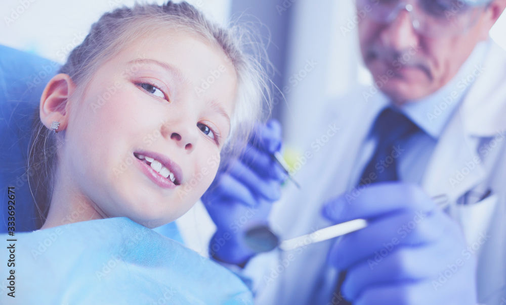 Naklejka premium Little girl sitting in the dentists office