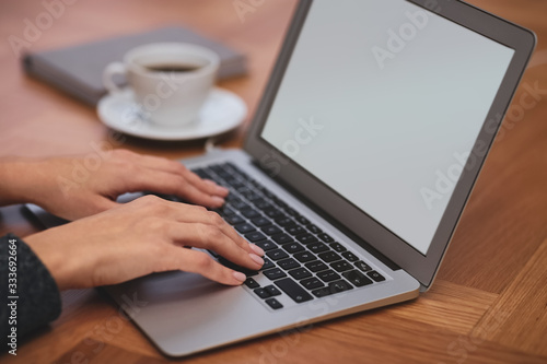 Woman working on modern laptop at table, closeup