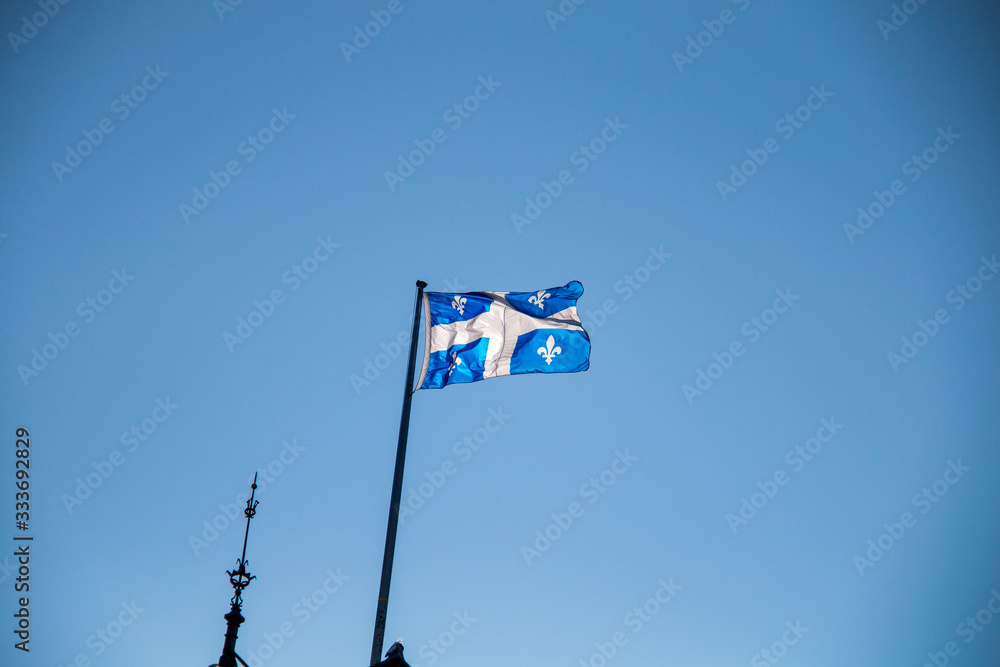 Fototapeta premium Flaga prowincji Quebec przeciw błękitne niebo.