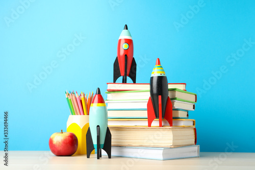 Bright toy rockets and school supplies on wooden table