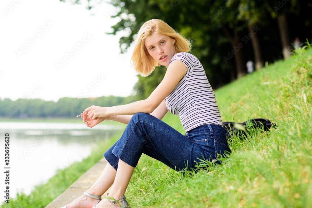 Summer vacation. Girl relaxing at riverside after working day. Woman dreaming about vacation. Rest relax and hobby. Spend free time for yourself. Girl sit on green grass near river. Vacation season Summer vacation. Girl relaxing at riverside after working day. Woman dreaming about vacation. Rest relax and hobby. Spend free time for yourself. Girl sit on green grass near river. Vacation season