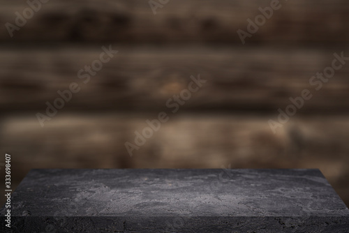 Black stone surface on wooden background .