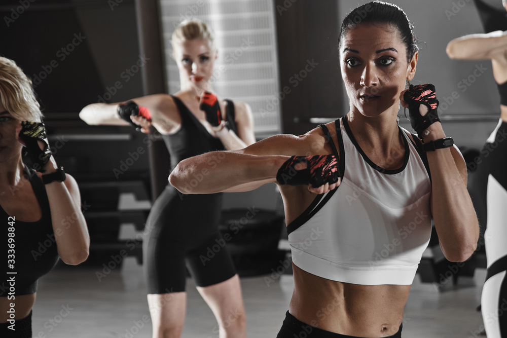 Women in black and white sportswear on a real group workout in the gym  train to fight, kickboxing with a trainer Stock Photo | Adobe Stock