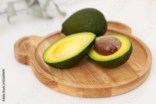 children's wooden plate in the shape of a bear with an avocado on the table