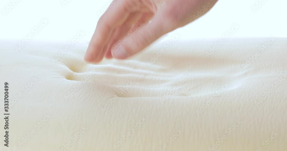Mano sta toccando un materasso in poliuretano con tecnologia memory foam.