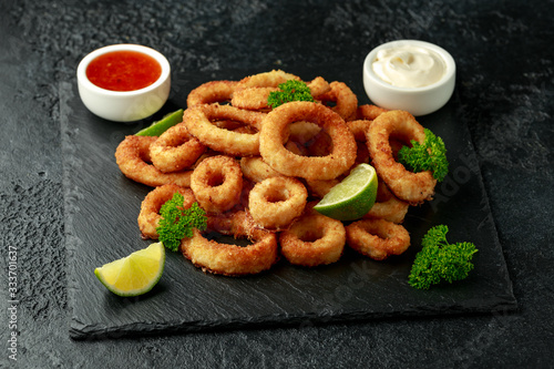 Photos Oven baked breaded calamari rings served with lime wedges, sweet chilli sauce an