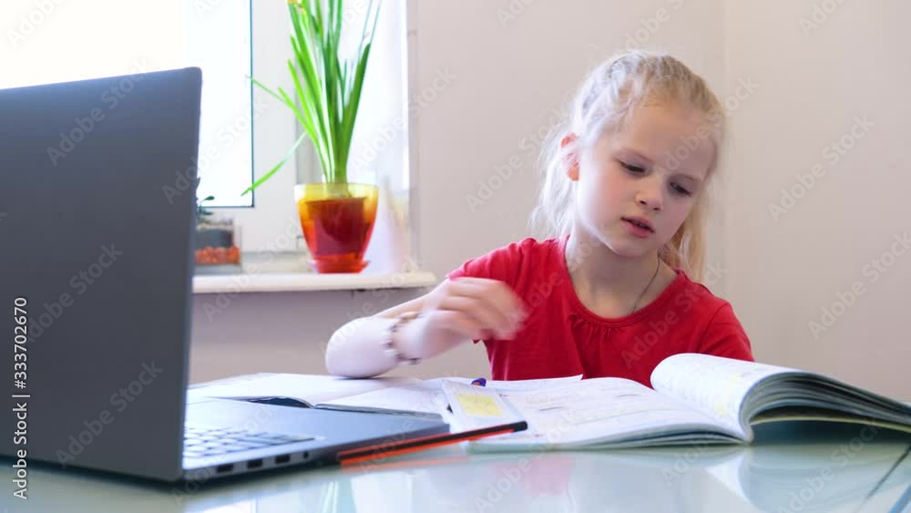 Distance learning online education. Schoolgirl studying at home with digital tablet and doing school homework. Training books and notebooks on table Distance learning online education. Schoolgirl studying at home with digital tablet and doing school homework. Training books and notebooks on table