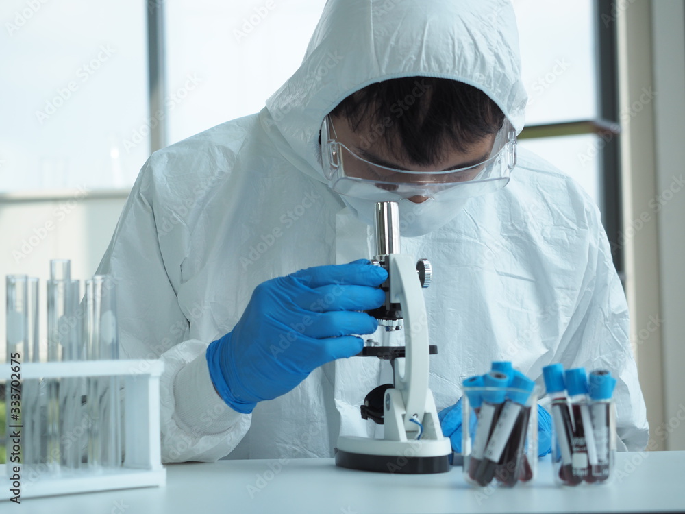 Asian male scientists or chemists or doctor or medical use microscopes at desks in medical laboratories or chemistry laboratory.Covid19 corona virus concept. Asian male scientists or chemists or doctor or medical use microscopes at desks in medical laboratories or chemistry laboratory.Covid19 corona virus concept.