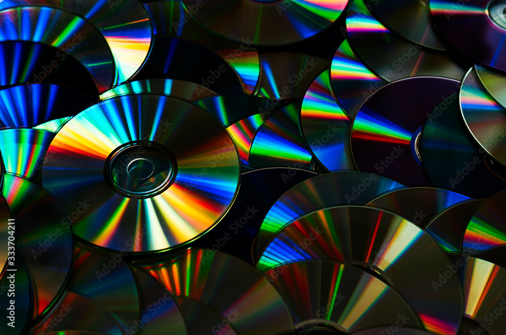 Group of old CD DVD compact optical disk storage medium with dust and scratches. Rainbow spectrum of iridescent colors Group of old CD DVD compact optical disk storage medium with dust and scratches. Rainbow spectrum of iridescent colors