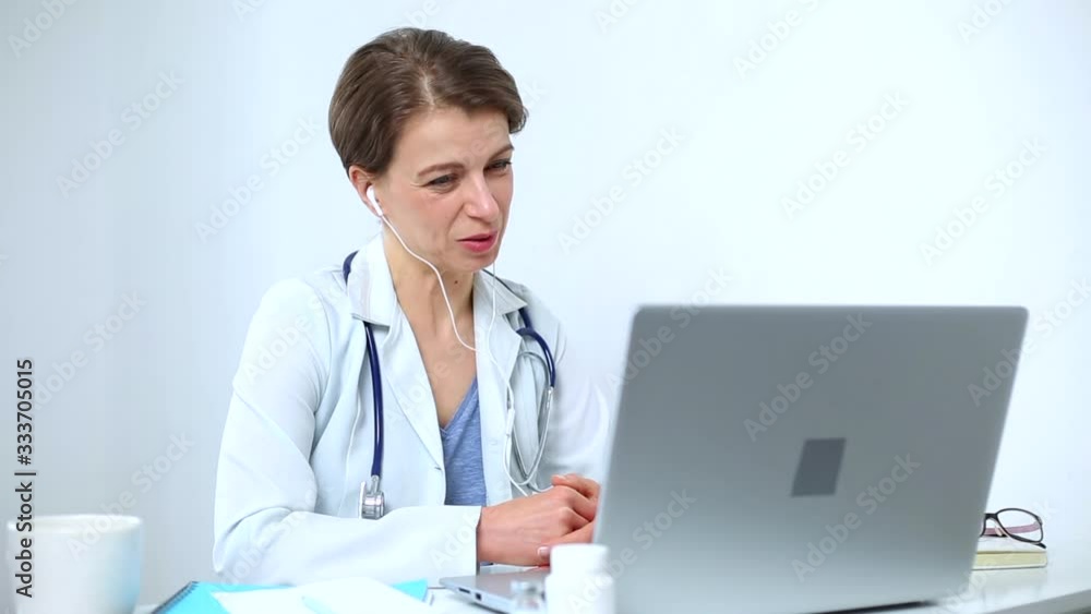 A female doctor is consulting a patient online video chat on a laptop. A female doctor is consulting a patient online video chat on a laptop.