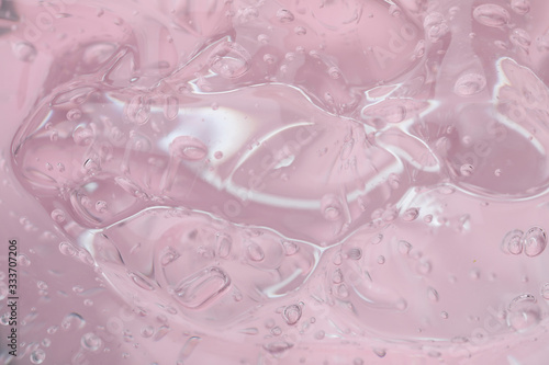 Pure transparent cosmetic gel on pink background, closeup
