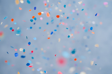 Colorful confetti falling on a holiday on a blue background