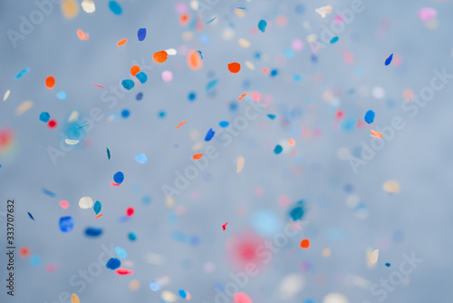 Colorful confetti falling on a holiday on a blue background photo