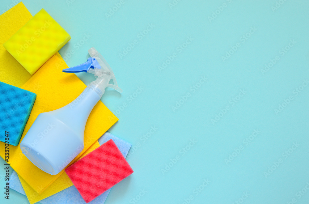 Cleaning set for different surfaces in kitchen, bathroom and other rooms. spray bottle with Shape Sponge and kitchen rags on a blue background. flat lay, Cleaning service concept. Spring cleaning. Cleaning set for different surfaces in kitchen, bathroom and other rooms. spray bottle with Shape Sponge and kitchen rags on a blue background. flat lay, Cleaning service concept. Spring cleaning.
