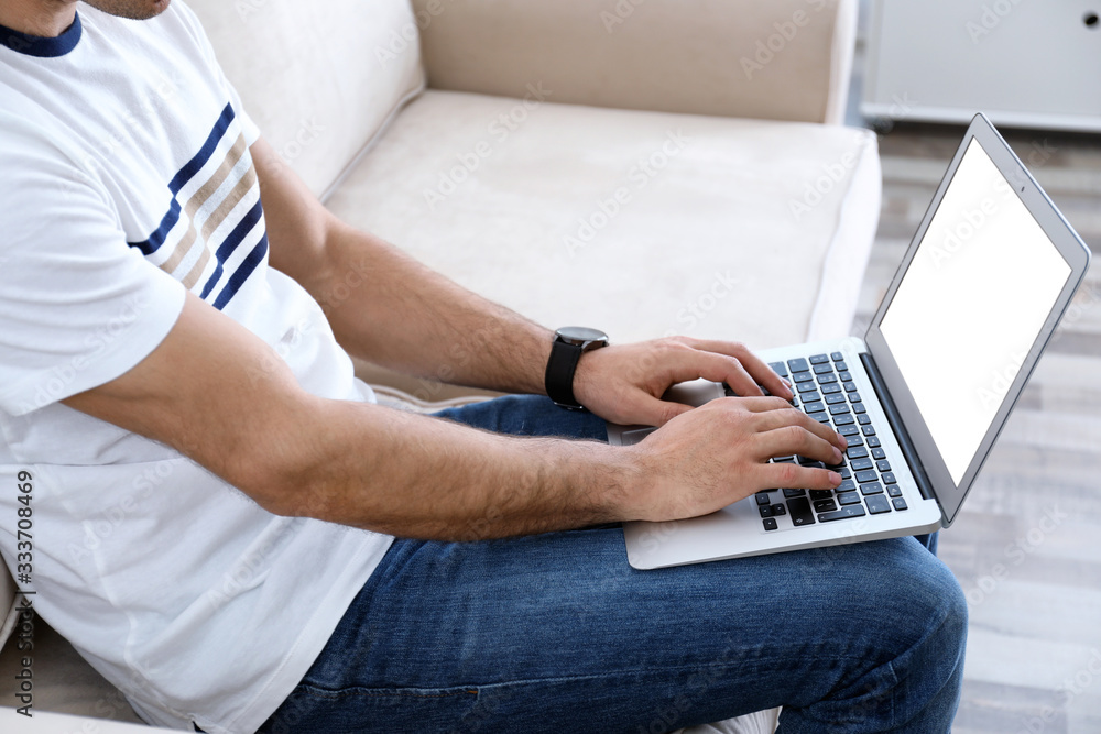 Fototapeta premium Man working on modern laptop at home, closeup