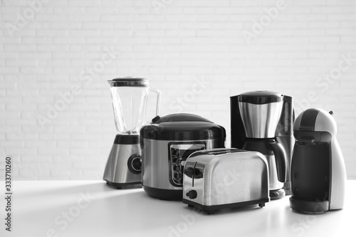 Set of modern home appliances on white table photo