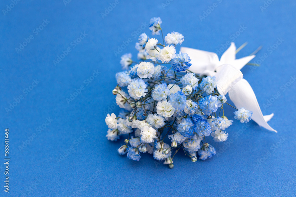 Bouquet of white-blue gypsophila flowers. with a white bow on a blue  background. Photos | Adobe Stock