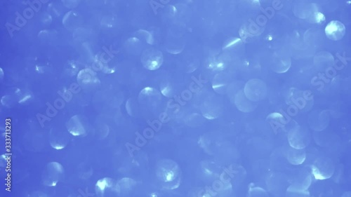 Closeup view video footage of beautiful sparkling blue color blurry holiday background spinning around slowly. photo