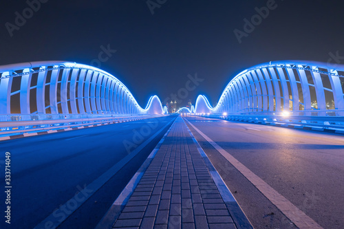 Photography Meydan Bridge and street road or path way on highway with modern architecture buildings in Dubai Downtown at night, urban city at night, United Arab Emirates or UAE