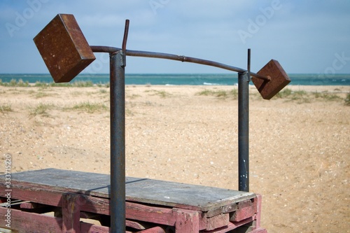 A handmade barbell for lifters on a beach. Motivation.