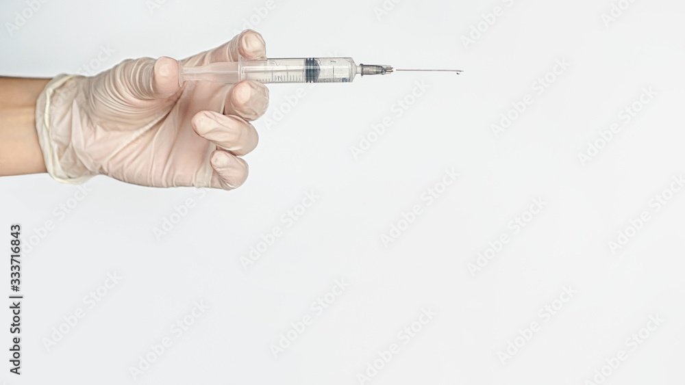 Hand in medical glove with syringe. Close up. For medical publications, immunization and vaccination campaign of people against infection and bacterial disease Hand in medical glove with syringe. Close up. For medical publications, immunization and vaccination campaign of people against infection and bacterial disease