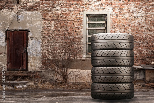 a stack of summer tires against a brick wall photo