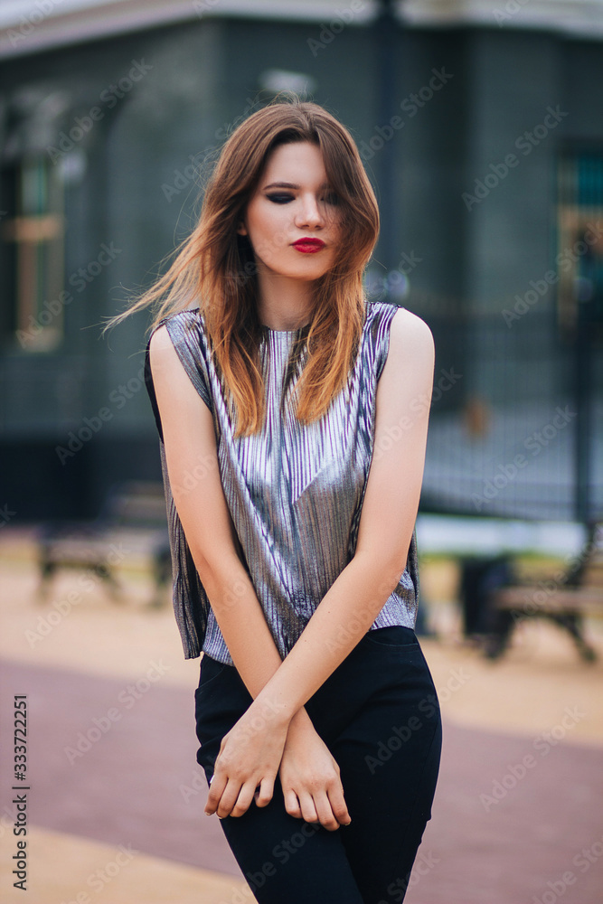 Beautiful, young, fashionable girl on the background of the building. Street fashion photo. Model with clean skin.