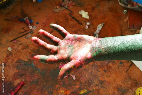 Hands of a child in paint playing on the Sun in the time of isolation background. 