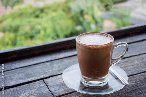 cappuccino chocolate cocoa with teaspoon isolated on wood table background.  photo