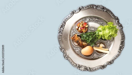 Pesach plate, on a dove-grey background, banner with a copyspace. Traditional Jewish seder on the occasion of Passover festival. photo