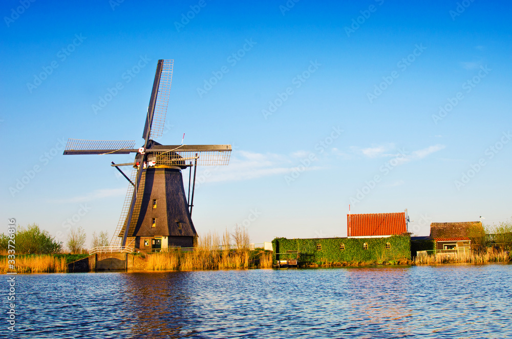 breathtaking beautiful inspirational landscape with a windmill in Kinderdijk, Netherlands. Fascinating places, tourist attraction.