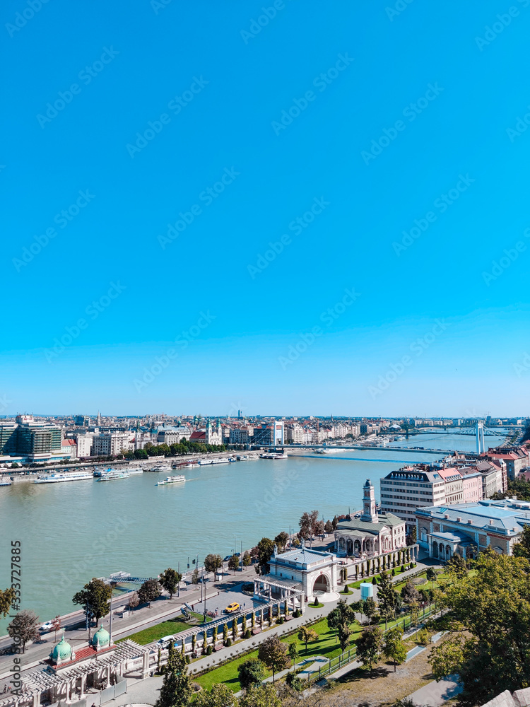 Fototapeta premium Amazing panorama of the city of Budapest on a sunny day. Bridge, river and small buildings. Vertical photo