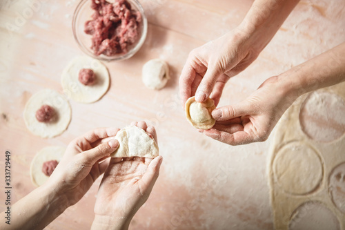family leisure. Man's hands preparing dough for ravioli, tortellin in vintage toning. Making baking.