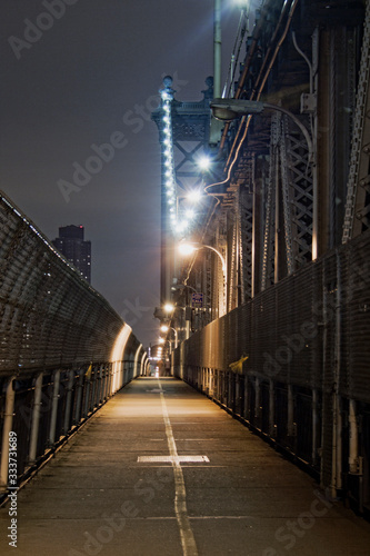 Manhattan Bridge at Night illuminated by lights. Sidewalk on Manhattan Bridge.