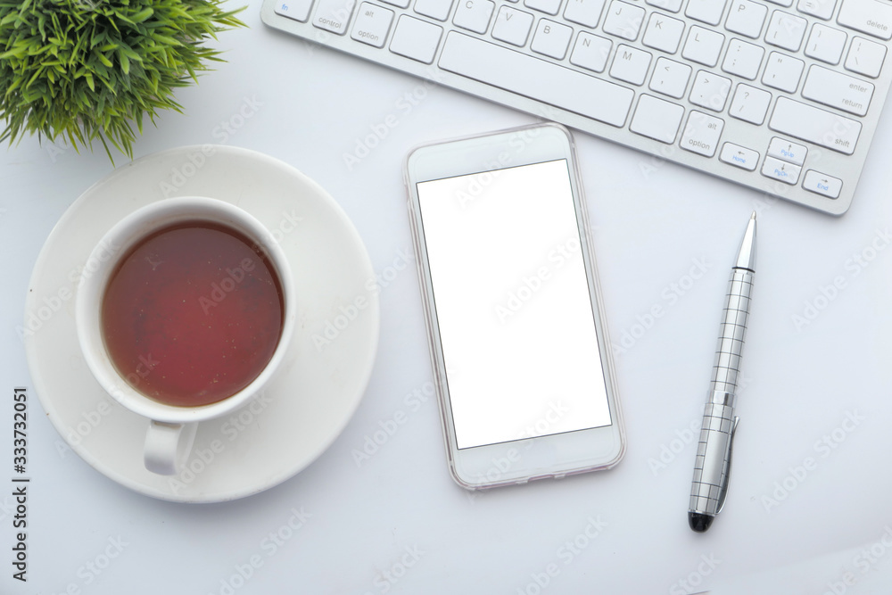 top view of smart phone with white screen on office desk top view of smart phone with white screen on office desk