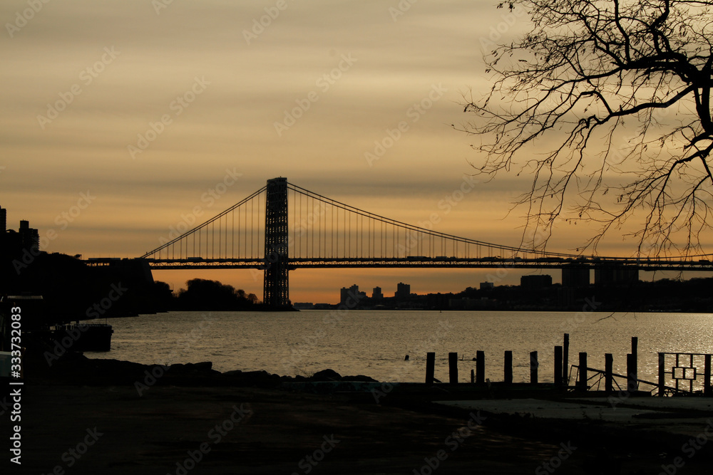 Obraz premium George Washington Bridge silhouette during Sundown over New York City and New Jersey. The George Washington Bridge spanning over the East River