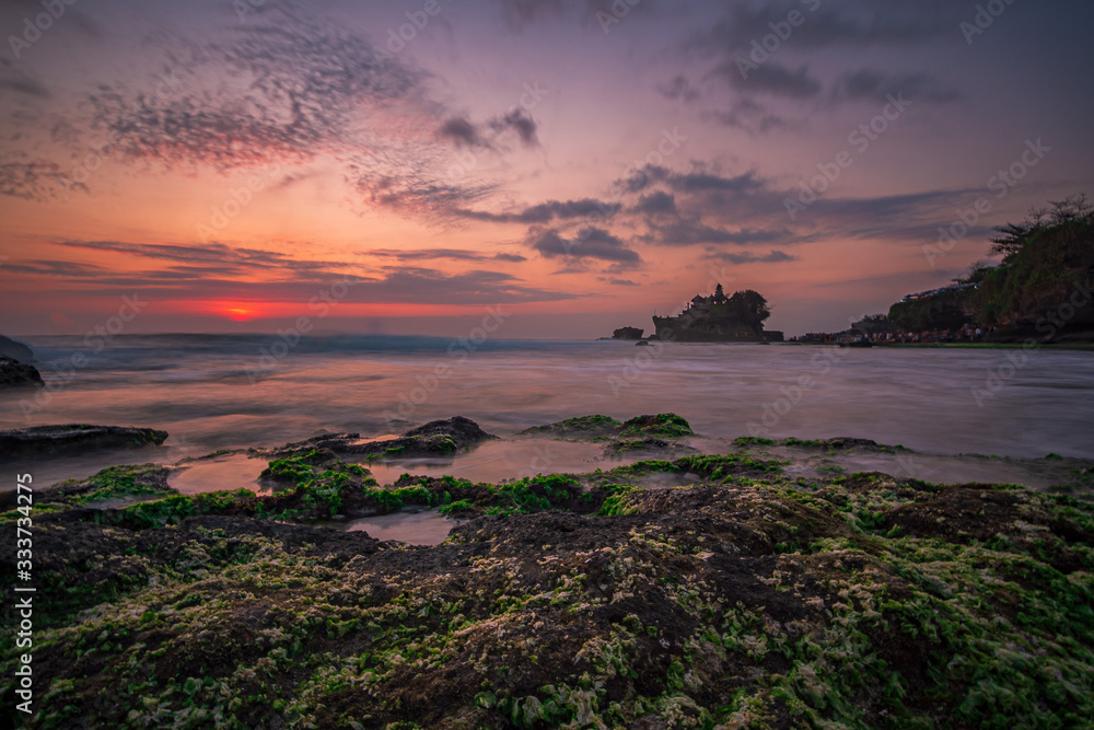 Pura Tanah Lot Temple, Bali at sunset. For the Balinese, Pura Tanah Lot is one of the most important and venerated sea temples. A long exposure photograph.