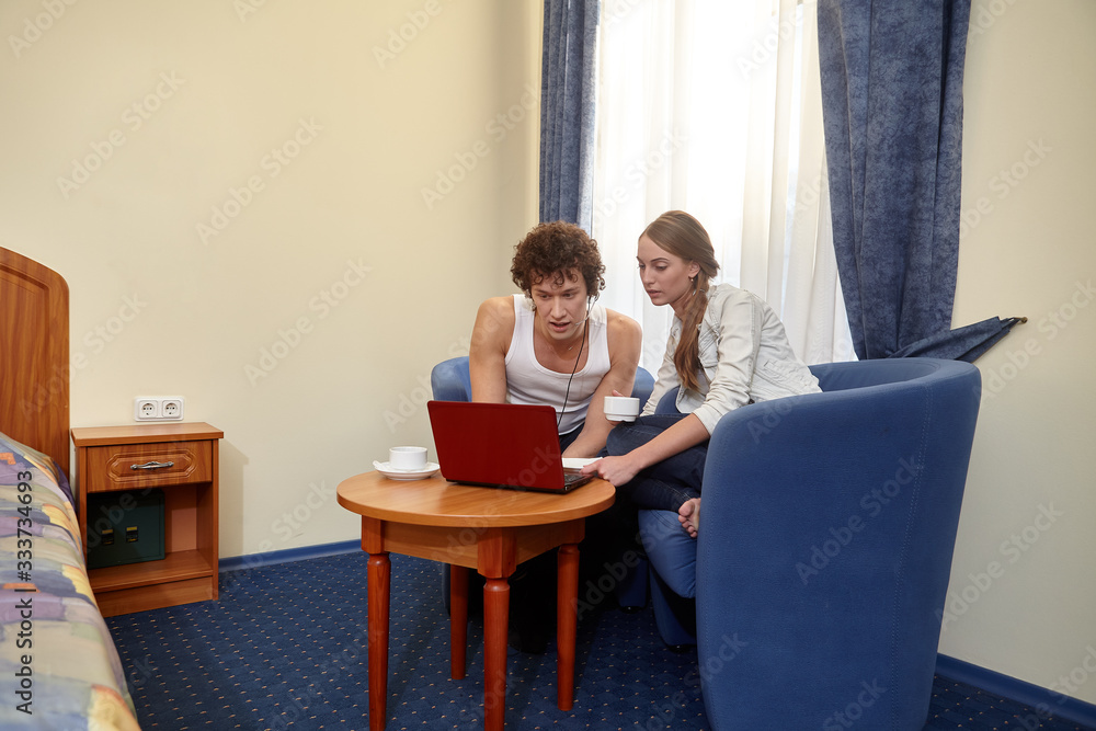 Young family with laptop are sitting in living room at home. Internet communication. Isolation period, social distancing Young family with laptop are sitting in living room at home. Internet communication. Isolation period, social distancing