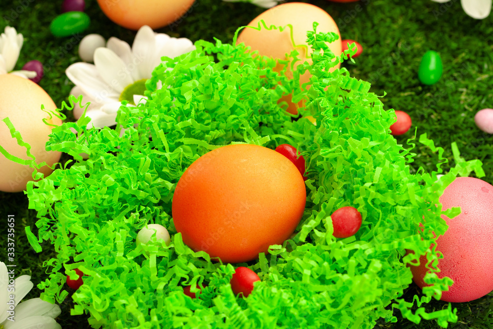 Close up photo of colored Easter eggs and candies on grass Close up photo of colored Easter eggs and candies on grass